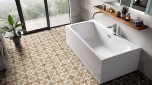 Modern white bathtub with sleek chrome faucet in stylish bathroom with patterned floor tiles and natural light.