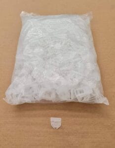 Clear plastic bag containing small white plastic edging clips for home improvement projects.