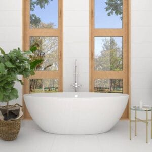 Modern freestanding white bathtub with a scenic view of trees through large wooden-framed windows, surrounded by a potted plant and a small side table, ideal for luxury bathroom renovation.