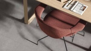 Comfortable red fabric office chair with black metal legs in a modern workspace.