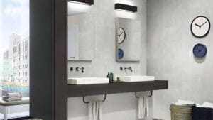 Modern bathroom with double vessel sinks, wall mirrors, and wall clocks, featuring sleek fixtures and ample storage space for home renovation projects.