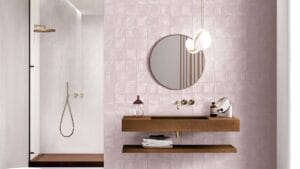 Modern bathroom vanity with pink tiled wall, round mirror, wooden floating shelves, and minimalist fixtures. Stylish and functional design for contemporary bathrooms.