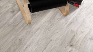 Light grey wood-look flooring planks showcasing durable laminate or vinyl flooring options for home renovation projects.