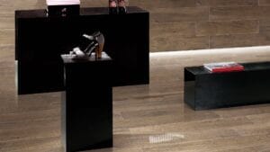 Sleek black display tables showcasing stylish footwear and accessories in a modern home decor setting.