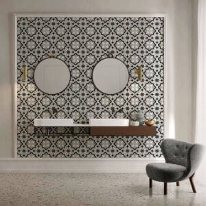 Bold geometric patterned wall tiles in black, white, and gray add a modern, stylish touch to bathroom decor. Features a sleek floating vanity with round mirrors and contemporary accessories, enhancing interior design.