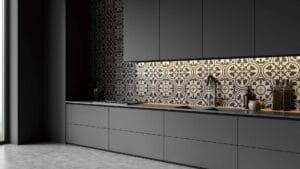 Modern gray kitchen cabinets with black and gray decorative backsplash, minimalist design, under-cabinet lighting, and sleek black faucet.