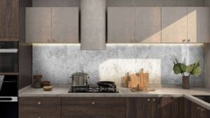 Modern kitchen with grey cabinetry, stone countertops, and a mosaic tile backsplash, featuring cooking essentials and decorative plants. Perfect for contemporary home renovations and DIY kitchen upgrades.