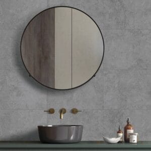 Sleek modern bathroom vanity with round mirror, minimalist black and gold fixtures, and stone countertop for contemporary home renovation.