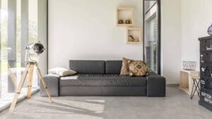 Modern living room with black leather sofa, large floor-to-ceiling windows, wooden decorative crates, and vintage style lighting by Builders Warehouse Online.