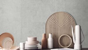 Sleek countertop display of modern ceramic dishes, vases, and kitchen accessories against a gray textured wall, showcasing stylish homeware and kitchen essentials from Builders Warehouse Online.