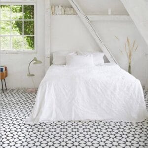 Tile Samples 33 Bright white bedding on a cozy, minimalist bedroom with black and white patterned flooring, natural light from large window, simple decor, perfect for home renovation and interior design projects.