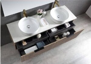 Double white bathroom sinks with modern gold fixtures on a marble countertop in a stylish bathroom setting.