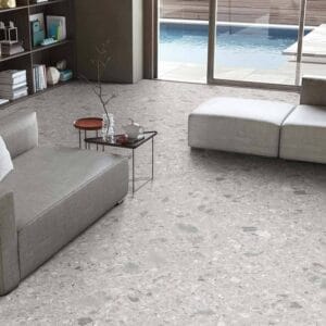 Gray polished concrete flooring with modern living room furniture, glass sliding doors showing backyard pool, ideal for contemporary home interior and outdoor entertainment spaces.