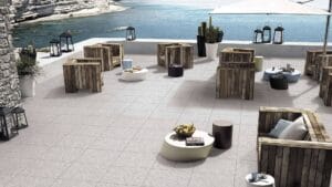 Stylish outdoor patio with wooden furniture, plant pots, and scenic ocean view, perfect for relaxing or entertaining, from Builders Warehouse Online.