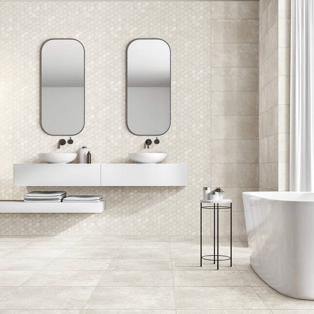 Modern minimalist bathroom with double sinks, oval mirrors, neutral tiles, and a sleek freestanding bathtub, showcasing stylish bathroom fixtures and contemporary design.