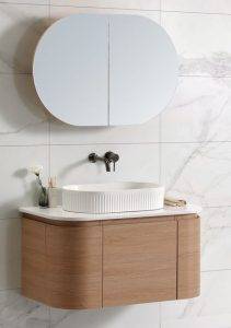 Modern bathroom vanity with round vessel sink, wall-mounted mirror, and minimalist decor, emphasizing stylish bathroom renovation and plumbing fixtures.