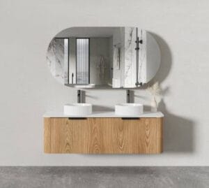 Contemporary bathroom vanity with two white vessel sinks, oval mirror, and light wood cabinet in a modern, minimalist design.