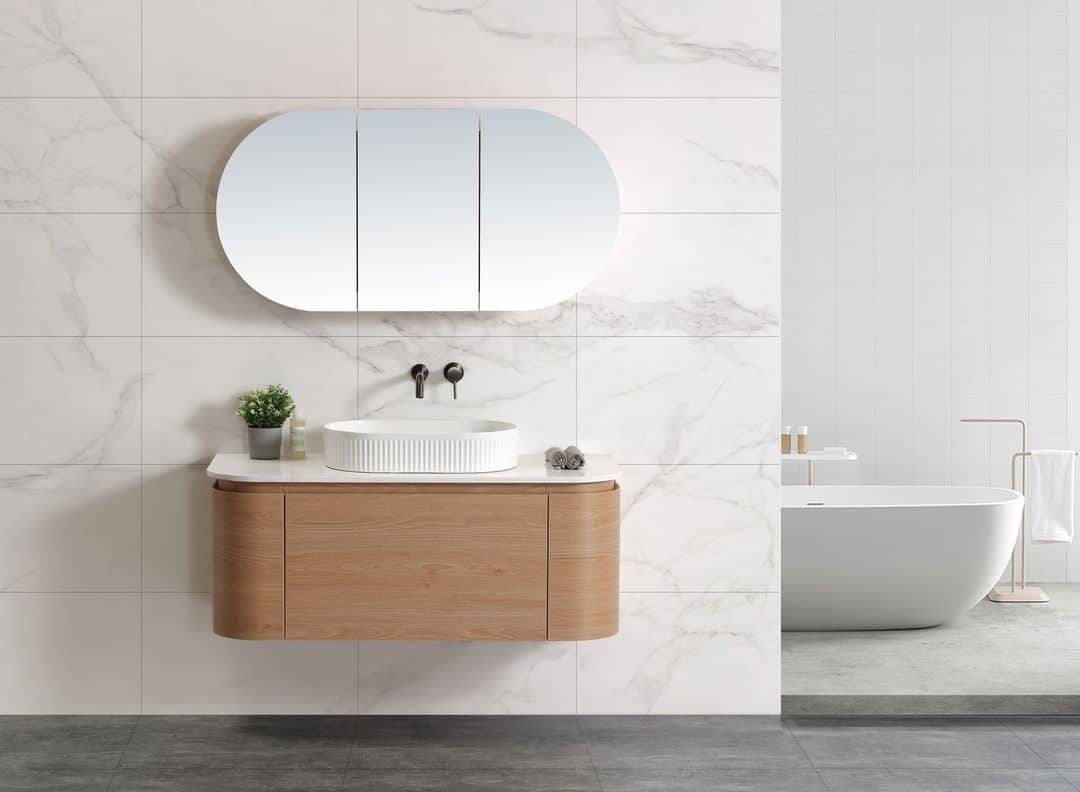Modern minimalist bathroom vanity with a round vessel sink, wall-mounted mirror cabinet, and a freestanding bathtub in a sleek, contemporary bathroom setting.