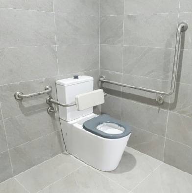 Accessible disabilities bathroom toilet with safety grab rails and support bars in a modern tiling setting.